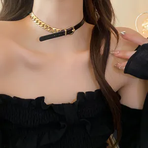 Close-up of a stylish gold chain and black leather belt buckle choker necklace on model