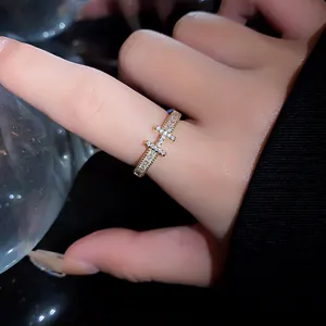 Macro view of a gold-plated zircon open ring on a finger, highlighting luxury detail.