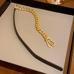 Detail of gold chain and black leather choker necklace with horseshoe buckle closure