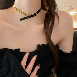 Detail shot of a leather and gold chain choker with belt buckle design on a model.