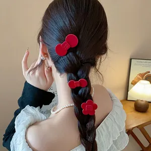 Elegant red resin flower and bow hair clips set worn on a woman's braided hairstyle.