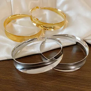 Nahaufnahme eleganter goldener und silberner Creolen mit polierter Metalloberfläche.