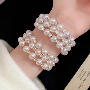 Close-up of elegant triple-layer pearl bracelet with sparkling rhinestone spacers.