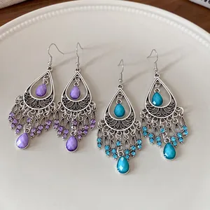 Vintage bohemian teardrop tassel earrings with purple and turquoise stones detail.