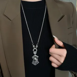 Vue détaillée d'un pendentif tête de mort en argent vintage sur un long collier pull