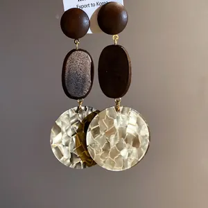 Macro detail view of elegant wood and ivory textured acetate round drop earrings for women
