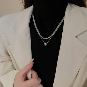 Détail d'un collier multicouche en argent avec zircone sur un col roulé noir élégant