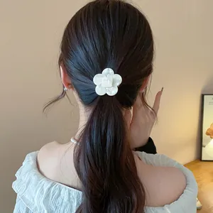 Detailed view of an elegant white resin flower hair clip on a model's ponytail