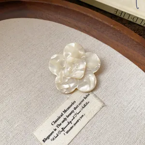 Close-up of elegant cream resin flower hair clip with pearl-like texture