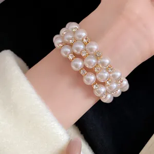 Close-up of an elegant triple-strand pearl bracelet with sparkling rhinestone accents.