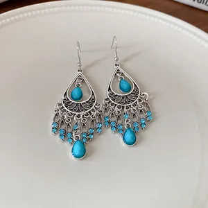 Detail shot of Bohemian style teardrop tassel earrings featuring blue rhinestones and stones