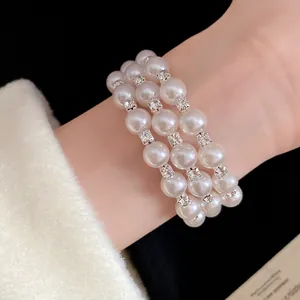 Detail shot of a triple-layer pearl and rhinestone bracelet with French retro style