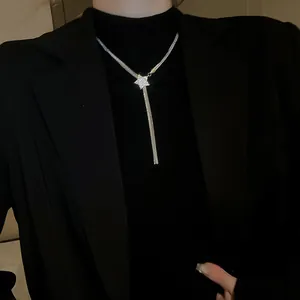 Long collier élégant avec pendentif étoile en zircon sur blazer noir et col roulé
