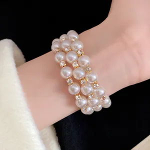Detailed close-up of a vintage three-row pearl bracelet with sparkling rhinestones