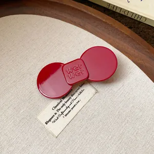 Close-up macro view of a vintage red resin bow-shaped duckbill hair clip accessory