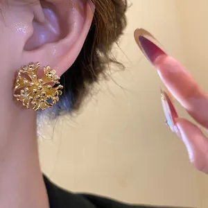 Detailed close-up showing 18k gold plated floral cluster ear clip worn on a model's ear