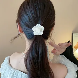 Detailed view of an elegant white resin flower hair clip styled on a model's ponytail.