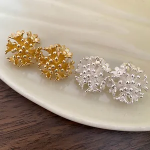 Close-up view of gold and silver floral cluster clip-on earrings in 18k gold plating