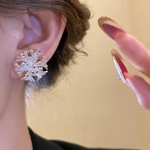 Detailed close-up view of an elegant 18k gold plated flower cluster stud earring on ear