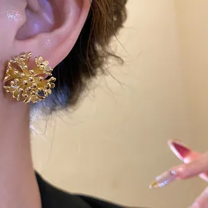 Elegant close-up shot of 18k gold plated flower cluster earrings worn on earlobe