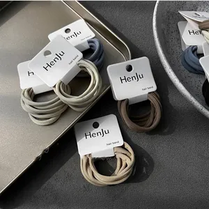 Detailed view of neutral-colored high-elastic hair bands organized on white display cards
