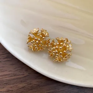 Close-up of 18k gold plated floral cluster clip-on earrings with textured petals