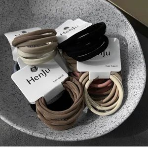 Detail view of high-elasticity hair ties set in earthy tones with brand packaging cards