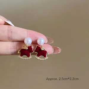 Gros plan détaillé des boucles d'oreilles cheval à bascule en velours et perles