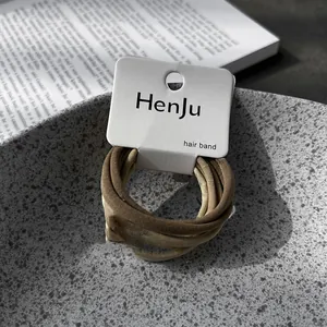 Macro view of high-elastic minimalist hair bands in earth tones on HenJu hangtag