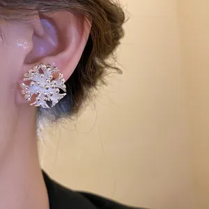 Exquisite close-up detail of a silver-toned floral cluster stud earring on a model's ear