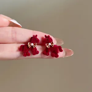 Boucles d'oreilles cheval en velours bordeaux élégantes avec un petit nœud en perles.
