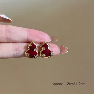 Vue détaillée des boucles d'oreilles gourde en velours rouge avec placage d'or