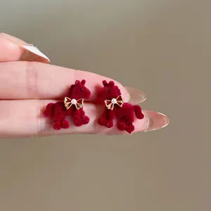 Vue détaillée des boucles d'oreilles cheval floqué rouge et perle