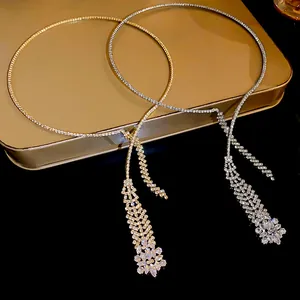 Close-up showing sparkling gold and silver zircon tassel necklaces on a metallic tray.