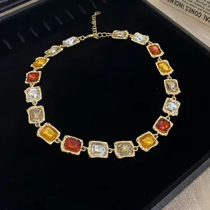 Detail view of multi-colored square crystal link necklace on black velvet display tray