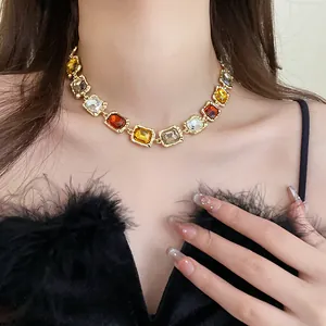 Close-up view of a multi-color square gemstone necklace on a model for fashion detail