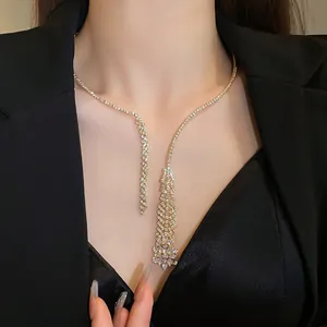 Detail shot of an elegant gold-toned tassel necklace with sparkling zircon stones