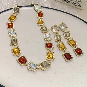 Detailed view of square multi-colored rhinestone necklace and earring set on a plate