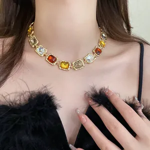 Close-up of vintage gold necklace with multi-colored rectangular crystals on model