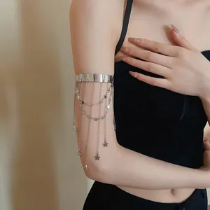 Detailopname van een stijlvolle zilveren bovenarmband met sterhangers en gelaagde kettingen.