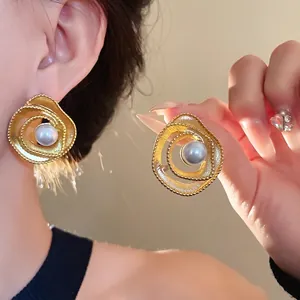 Vintage golden spiral stud earrings featuring an elegant artificial pearl center decoration