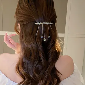 Elegant crystal tassel hair clip shown on wavy brown hair from a back view perspective