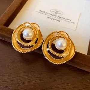 Elegant vintage gold spiral stud earrings with white faux pearl center decoration.