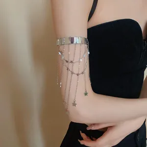 Detail van een zilveren armmanchet met sterren en fijne kettingfranjes op de arm