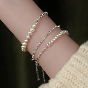 Dettaglio di un elegante bracciale a tre strati con perle e perle d'argento frantumato