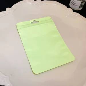 Close-up of a lime green resealable mylar bag for jewelry packaging on a white plate.