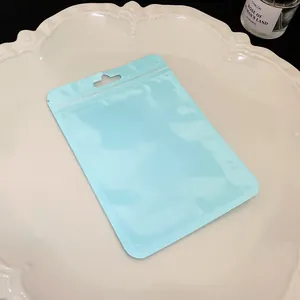 Close-up view of a matte macaron blue resealable zipper pouch with hanging hole for jewelry packaging