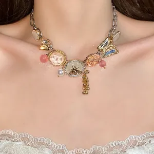 Ornate vintage crystal necklace featuring bee and butterfly charms with pearl accents