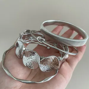 Stylish set of geometric silver metal bangles with irregular hammered and textured designs