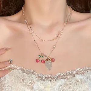 Close-up detail of double-layered necklace featuring crystal beads and fruit pendants